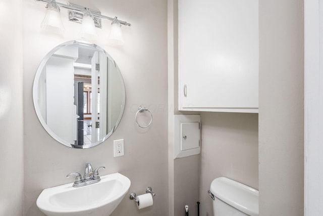 half bathroom featuring toilet and a sink