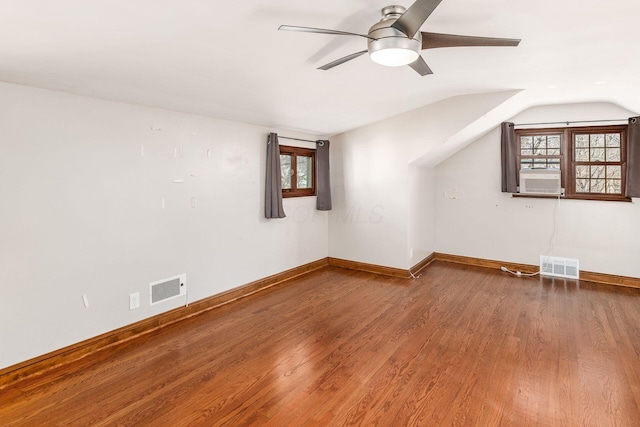 additional living space featuring baseboards, visible vents, vaulted ceiling, and wood finished floors