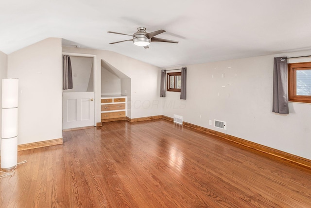 bonus room featuring visible vents, vaulted ceiling, baseboards, and wood finished floors