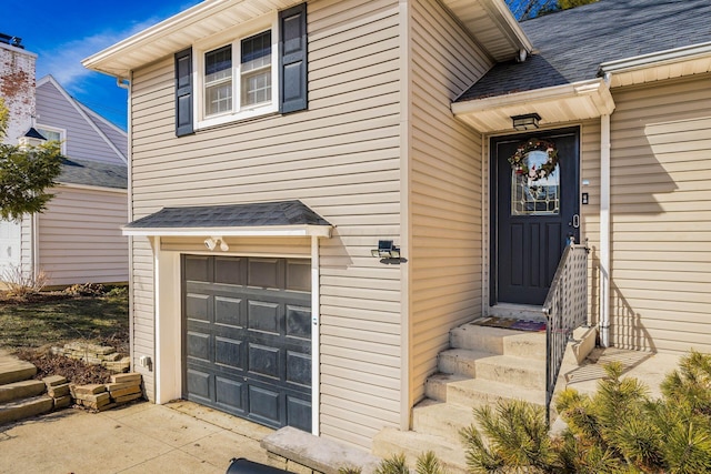 view of exterior entry featuring a shingled roof and an attached garage