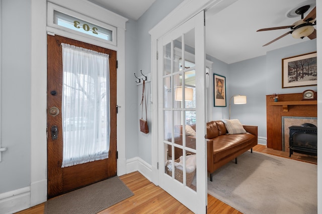 foyer entrance featuring ceiling fan, french doors, baseboards, and wood finished floors