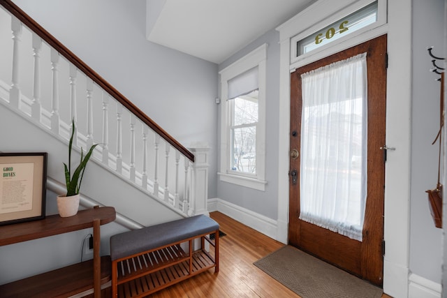 entrance foyer with stairway, baseboards, and light wood finished floors