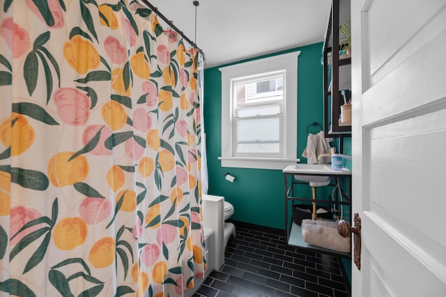 bathroom with a shower with curtain, tile patterned floors, and toilet