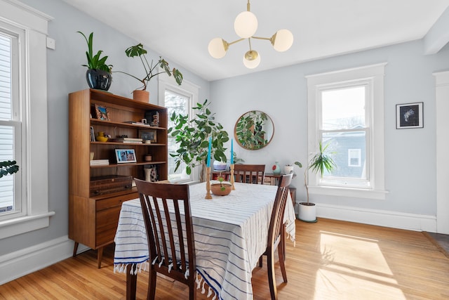 dining space with baseboards and light wood-style floors