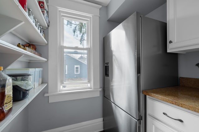 kitchen with white cabinetry, open shelves, and stainless steel refrigerator with ice dispenser