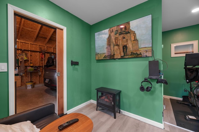 interior space featuring a wood stove, baseboards, and wood finished floors