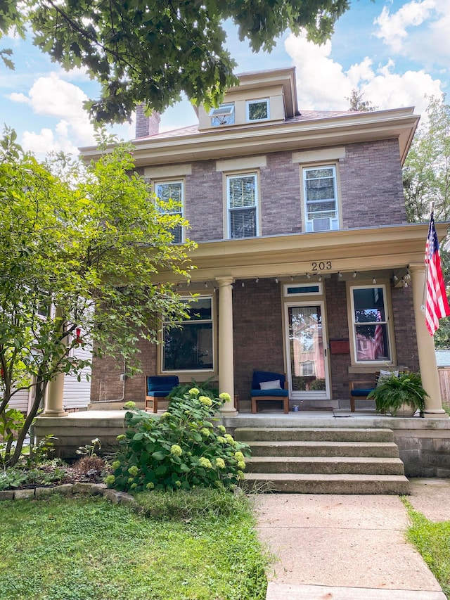 traditional style home featuring brick siding and covered porch