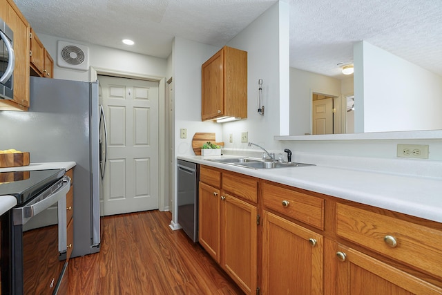 kitchen featuring stainless steel appliances, dark wood-type flooring, visible vents, light countertops, and brown cabinets