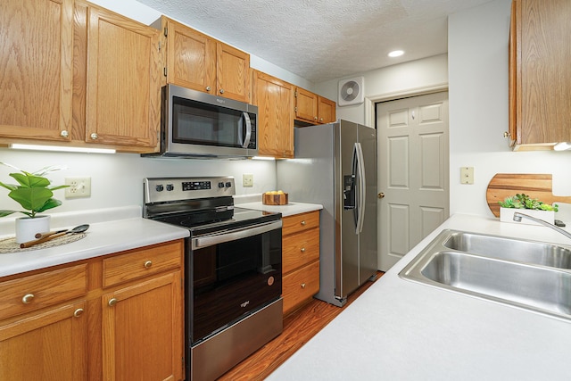 kitchen featuring light countertops, visible vents, appliances with stainless steel finishes, a sink, and a textured ceiling