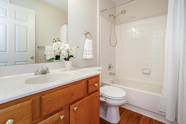 full bath featuring a textured ceiling, toilet, wood finished floors, vanity, and shower / tub combo with curtain