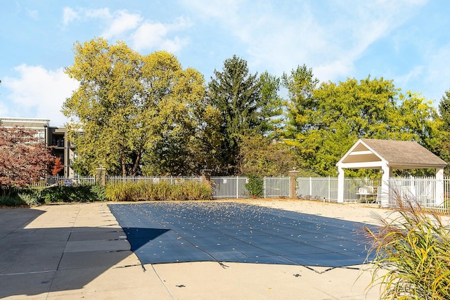 community pool with a gazebo, a patio, and fence