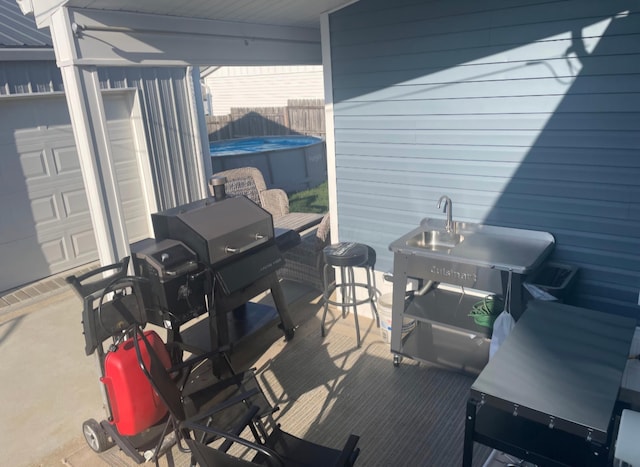 view of patio featuring an outdoor pool, a garage, and fence