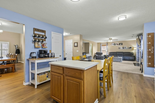 kitchen with brown cabinets, a center island, open floor plan, and light countertops