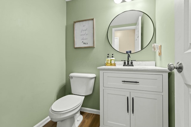 bathroom featuring wood finished floors, vanity, toilet, and baseboards