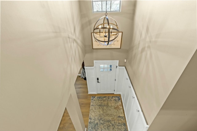 entryway featuring a high ceiling, an inviting chandelier, and wood finished floors