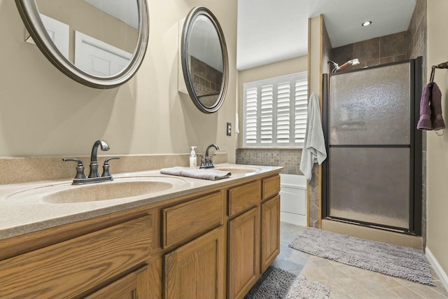 bathroom with double vanity, a shower stall, and a sink