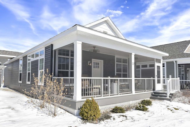 snow covered property with a shingled roof