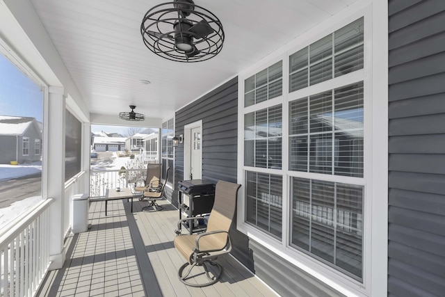 wooden deck with covered porch and a ceiling fan