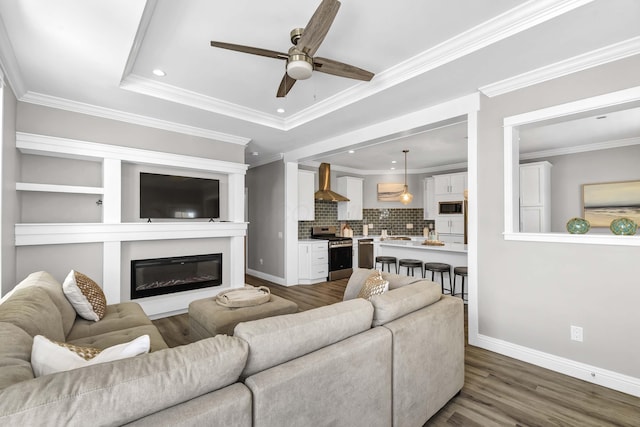 living area featuring crown molding, dark wood finished floors, and baseboards