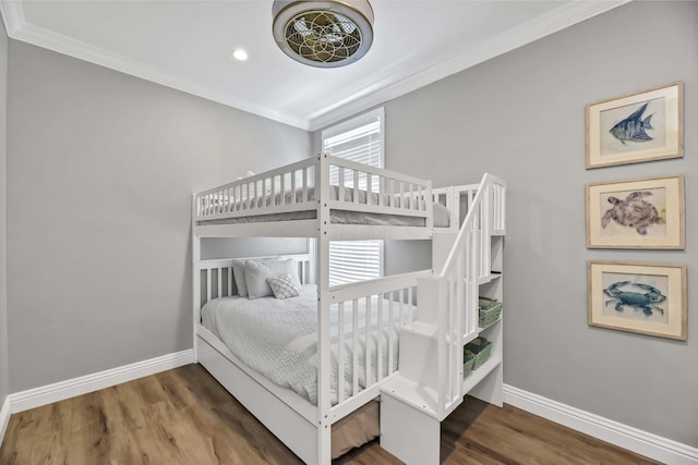 bedroom featuring crown molding, baseboards, and wood finished floors