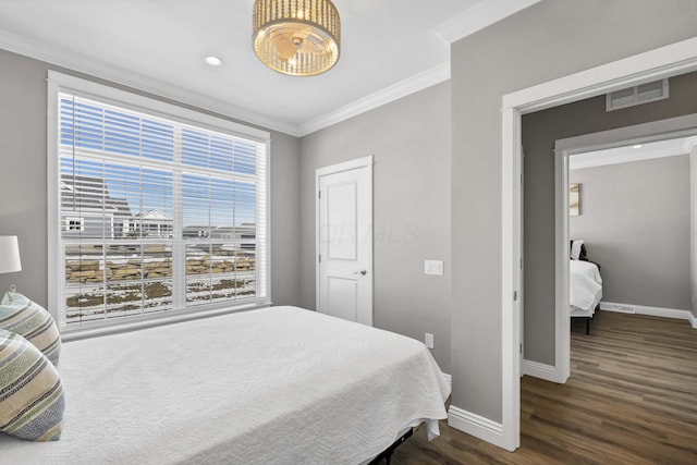 bedroom with ornamental molding, dark wood finished floors, visible vents, and baseboards