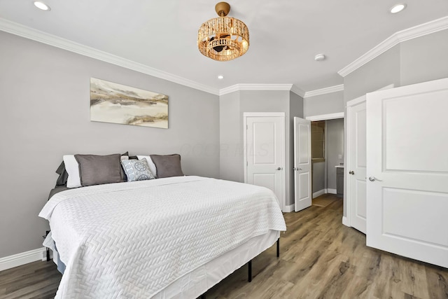 bedroom with recessed lighting, crown molding, baseboards, and wood finished floors