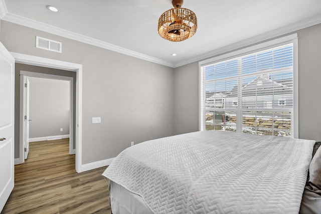 bedroom with baseboards, visible vents, ornamental molding, wood finished floors, and recessed lighting