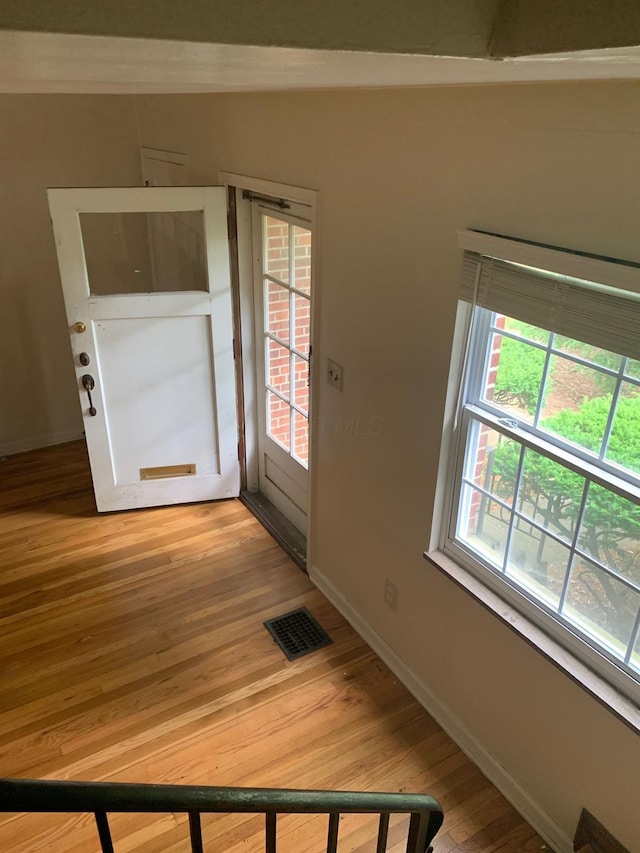 entrance foyer with baseboards, visible vents, and wood finished floors