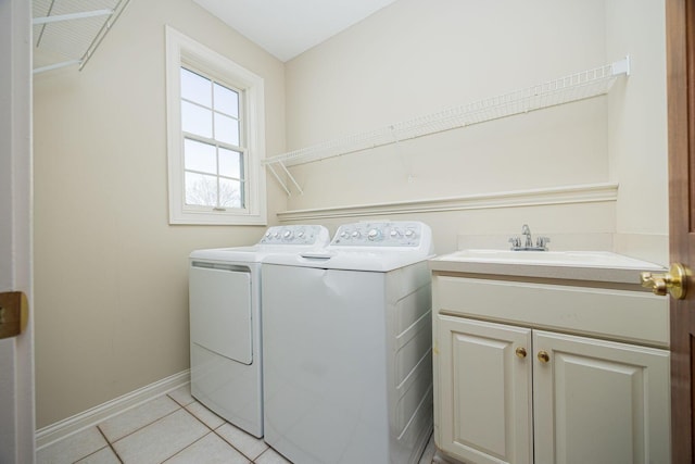laundry room featuring baseboards, washer and clothes dryer, light tile patterned floors, cabinet space, and a sink