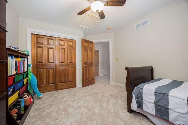 bedroom featuring visible vents, baseboards, ceiling fan, attic access, and light carpet