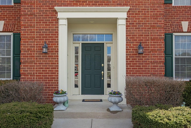 view of exterior entry featuring brick siding