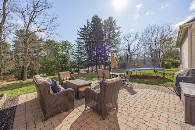 view of patio with grilling area, an outdoor hangout area, and a trampoline