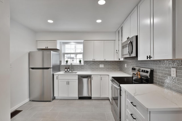 kitchen with light stone counters, tasteful backsplash, visible vents, appliances with stainless steel finishes, and a sink