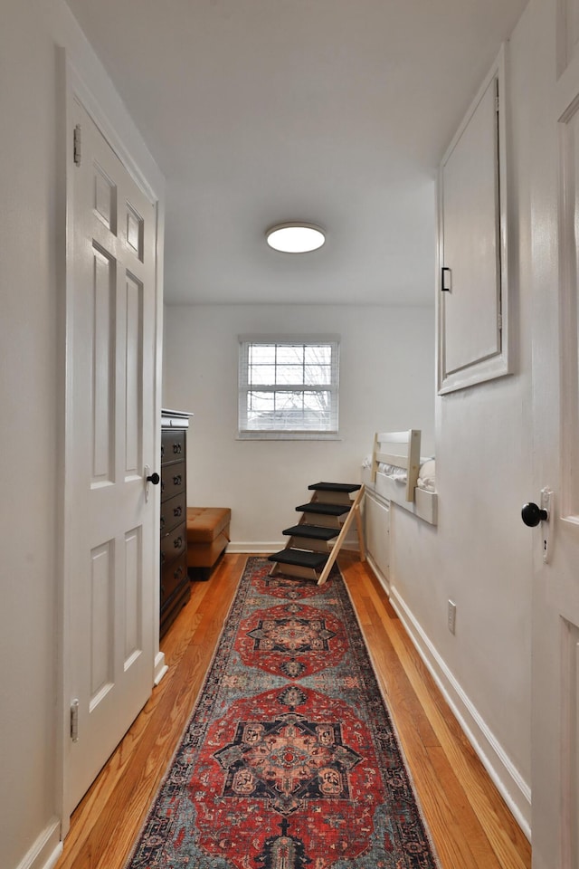 hallway featuring baseboards and light wood-style floors