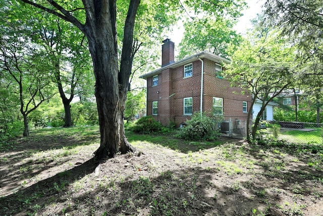 2938 Sherwood Rd, Columbus, OH 43209 - view of property exterior featuring a chimney, brick siding, fence, and central air condition unit