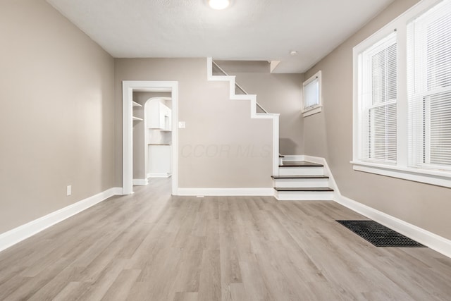 interior space with visible vents, baseboards, stairs, and light wood-style floors