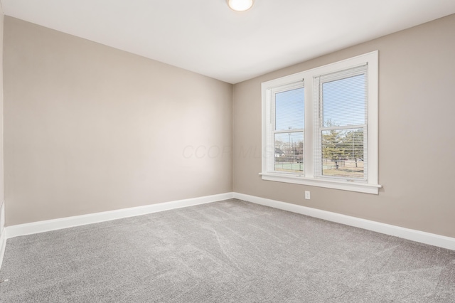 empty room featuring baseboards and carpet