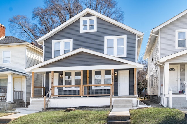 american foursquare style home featuring covered porch