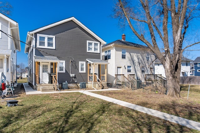 view of front of property featuring cooling unit, a front yard, and fence