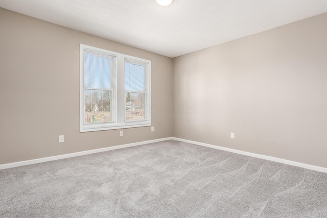 empty room featuring baseboards and carpet floors