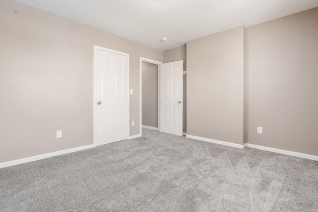 unfurnished bedroom with carpet flooring and baseboards