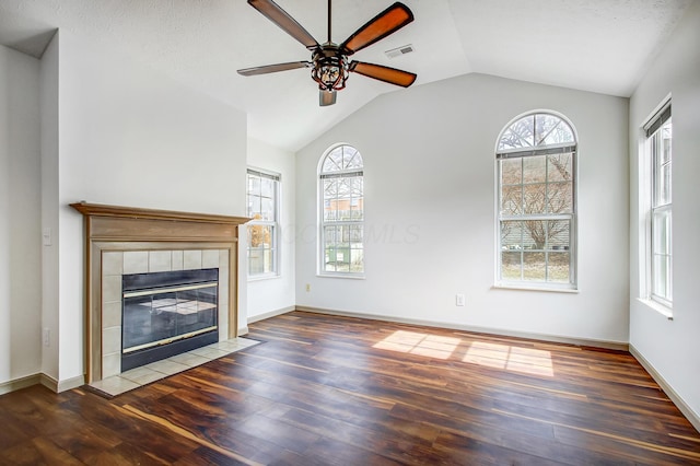 unfurnished living room featuring a tile fireplace, visible vents, dark wood finished floors, and lofted ceiling