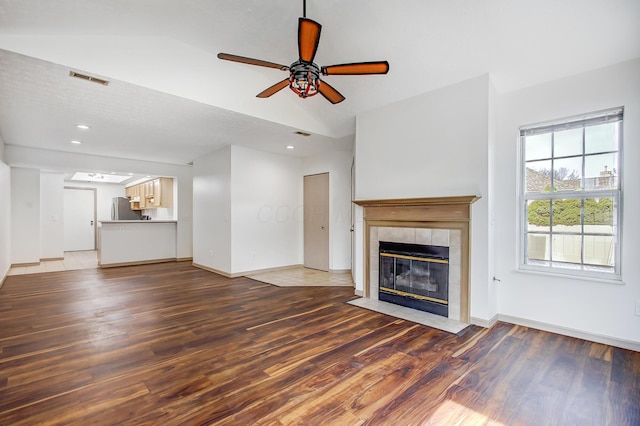 unfurnished living room featuring dark wood-type flooring, a fireplace, visible vents, and baseboards