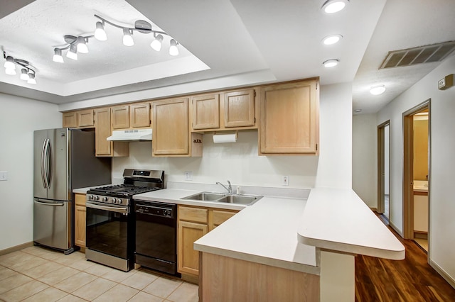 kitchen with under cabinet range hood, a sink, visible vents, light countertops, and appliances with stainless steel finishes