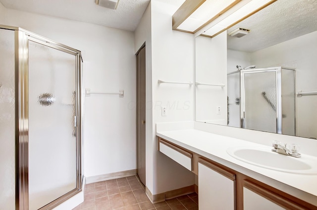 full bath featuring a textured ceiling, a stall shower, and vanity