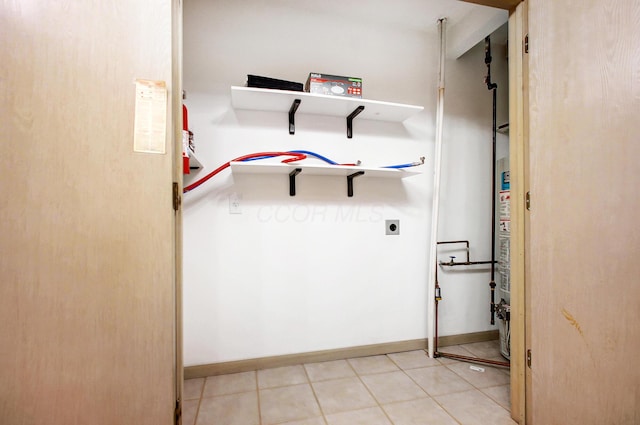 washroom featuring laundry area, hookup for an electric dryer, baseboards, and light tile patterned floors