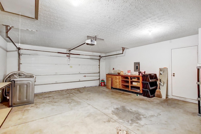 garage with a garage door opener and electric panel