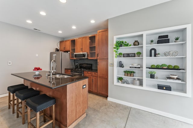 kitchen featuring brown cabinetry, a breakfast bar area, stainless steel appliances, and a sink