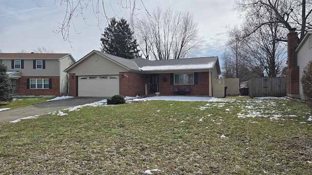 view of front facade featuring aphalt driveway, a garage, brick siding, a gate, and a front yard