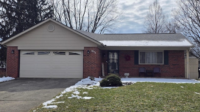 single story home featuring a garage, brick siding, and driveway